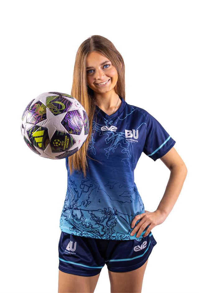 A player resting a football on her hip
